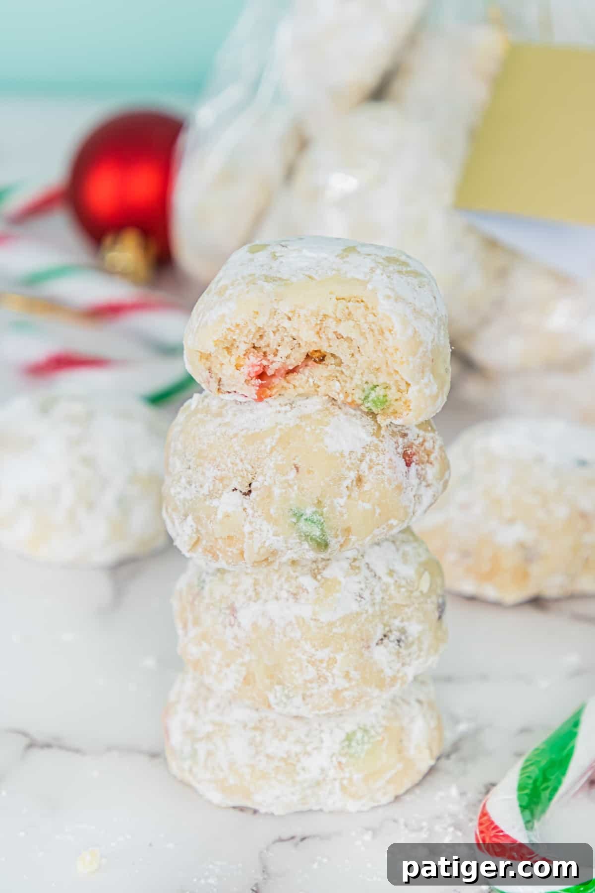 Crimson Swirl Snowball Delights 8 A close-up of finished Candy Cane Snowball Cookies, showing the vibrant red and green candy cane pieces perfectly embedded within the snowy white cookies.
