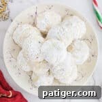 Crimson Swirl Snowball Delights 9 A smaller image of Peppermint Candy Cane Snowball Cookies on a festive serving plate, ideal for sharing.