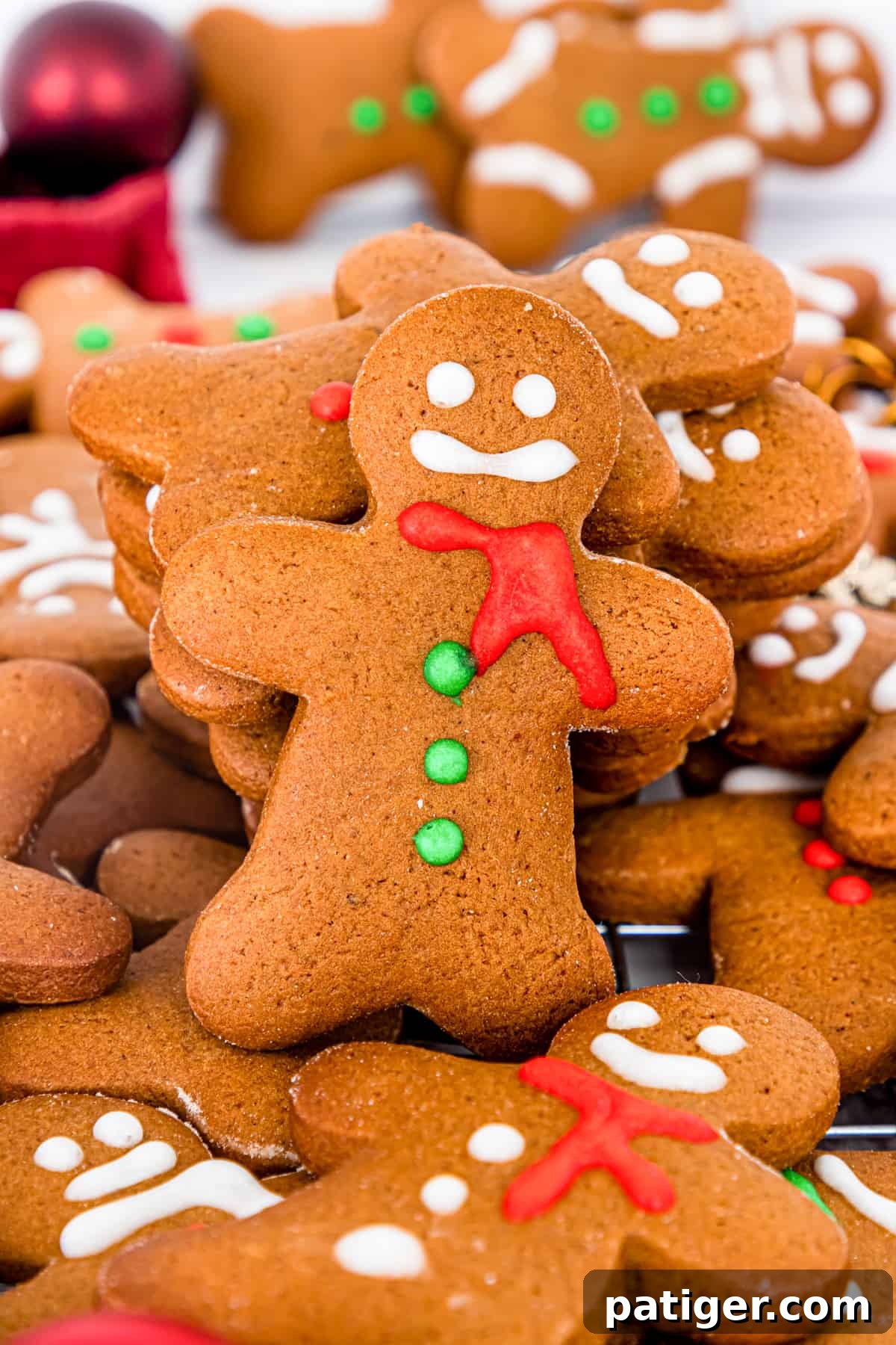 Homemade gingerbread men cookies decorated with eyes, mouth, scarf, and buttons using icing
