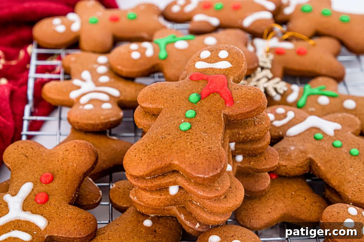 Christmas gingerbread men cookies decorated with eyes, buttons, and scarf using red, green, and white icing