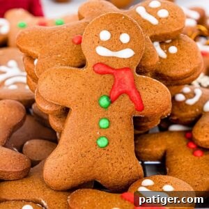 Homemade gingerbread men cookies decorated with eyes, mouth, scarf, and buttons using icing