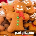 Homemade gingerbread men cookies decorated with eyes, mouth, scarf, and buttons using icing