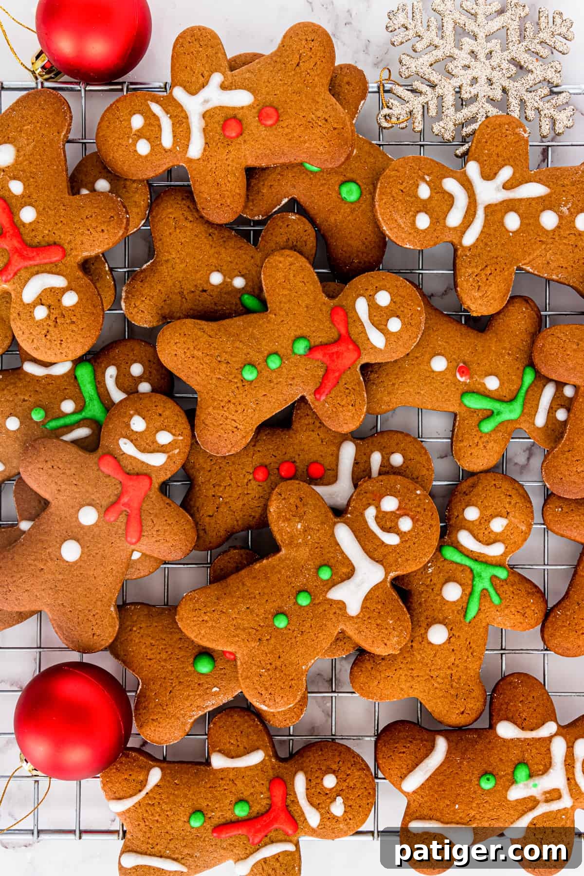 Christmas gingerbread men cookies scattered and piled on top of cooling rack