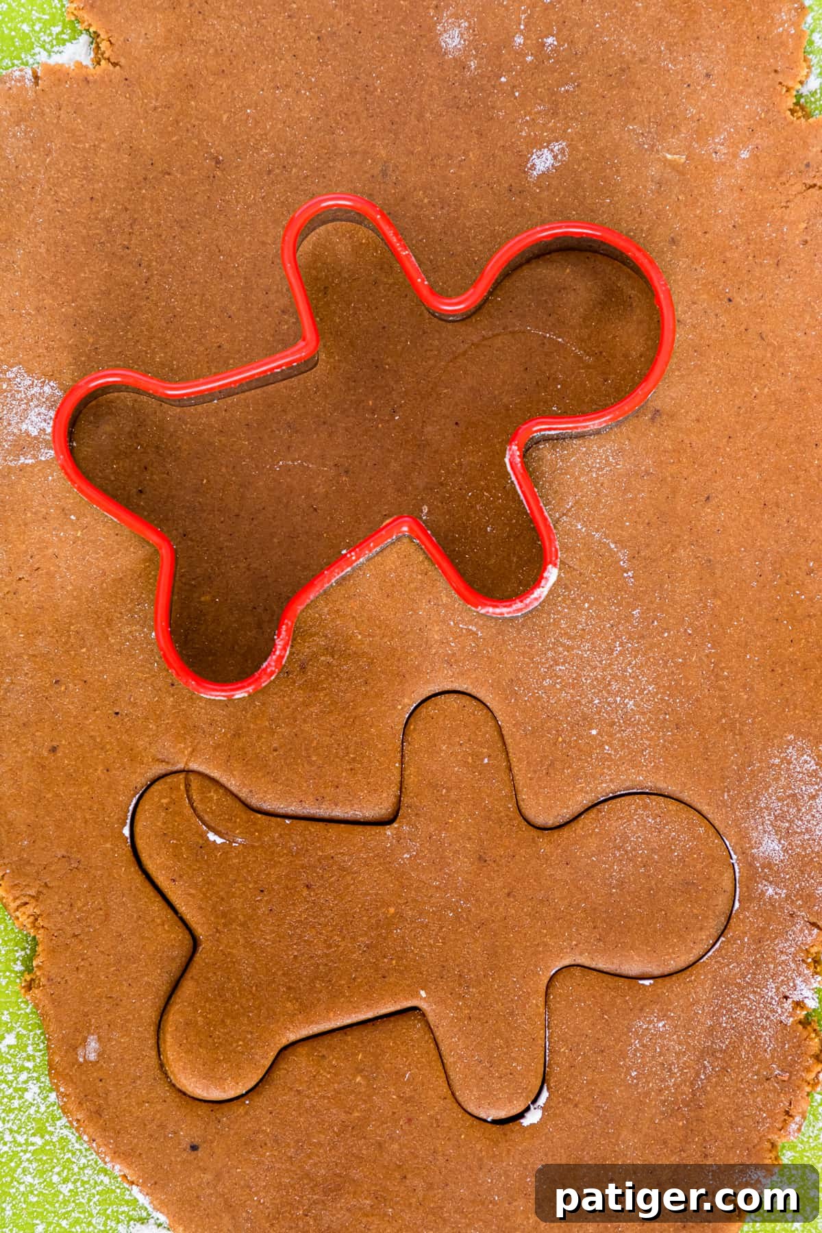 Man shaped cookie cutter cutting gingerbread cookie dough