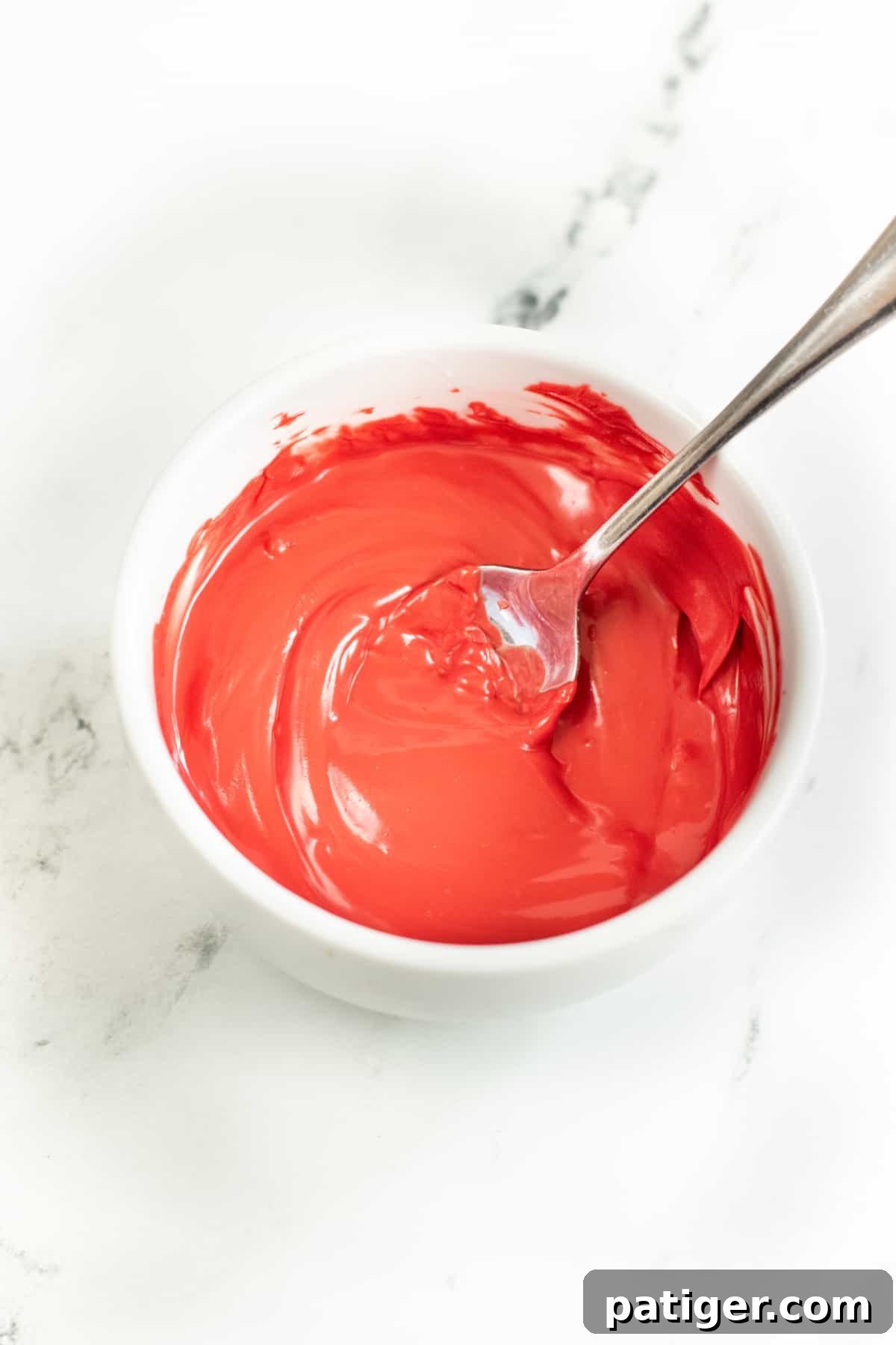 Holiday Pretzel Poppers 6 Smooth and creamy melted red candy melts in a bowl, perfectly prepared for drizzling.