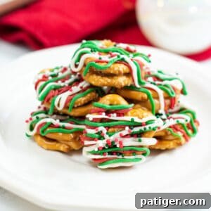 Caramel pretzel bites drizzled with green, red, and white candy melts and topped with holiday sprinkles