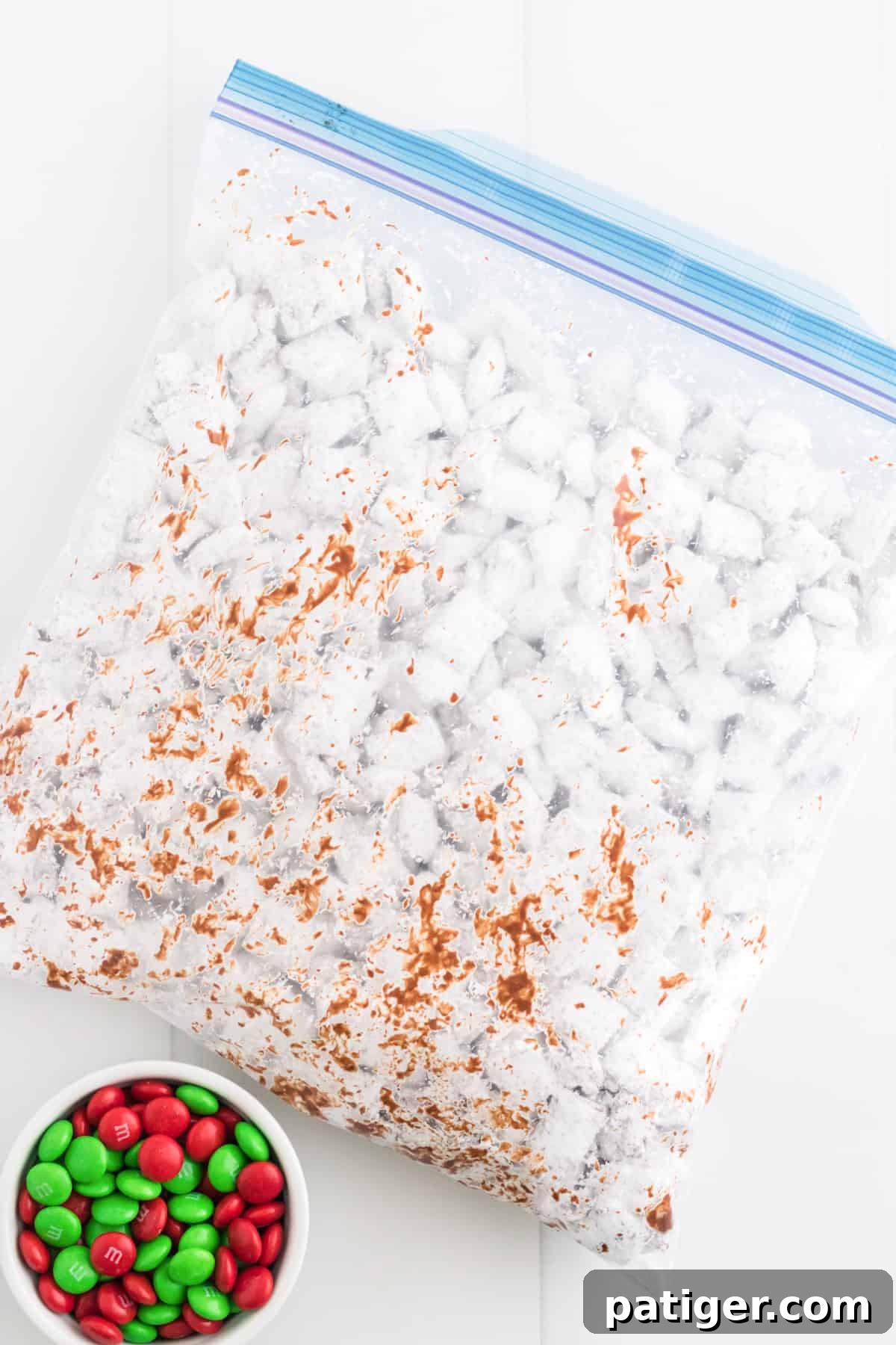 Gallon-size ziplock bag with muddy buddies inside. Bowl of red and green M&Ms are next to it.