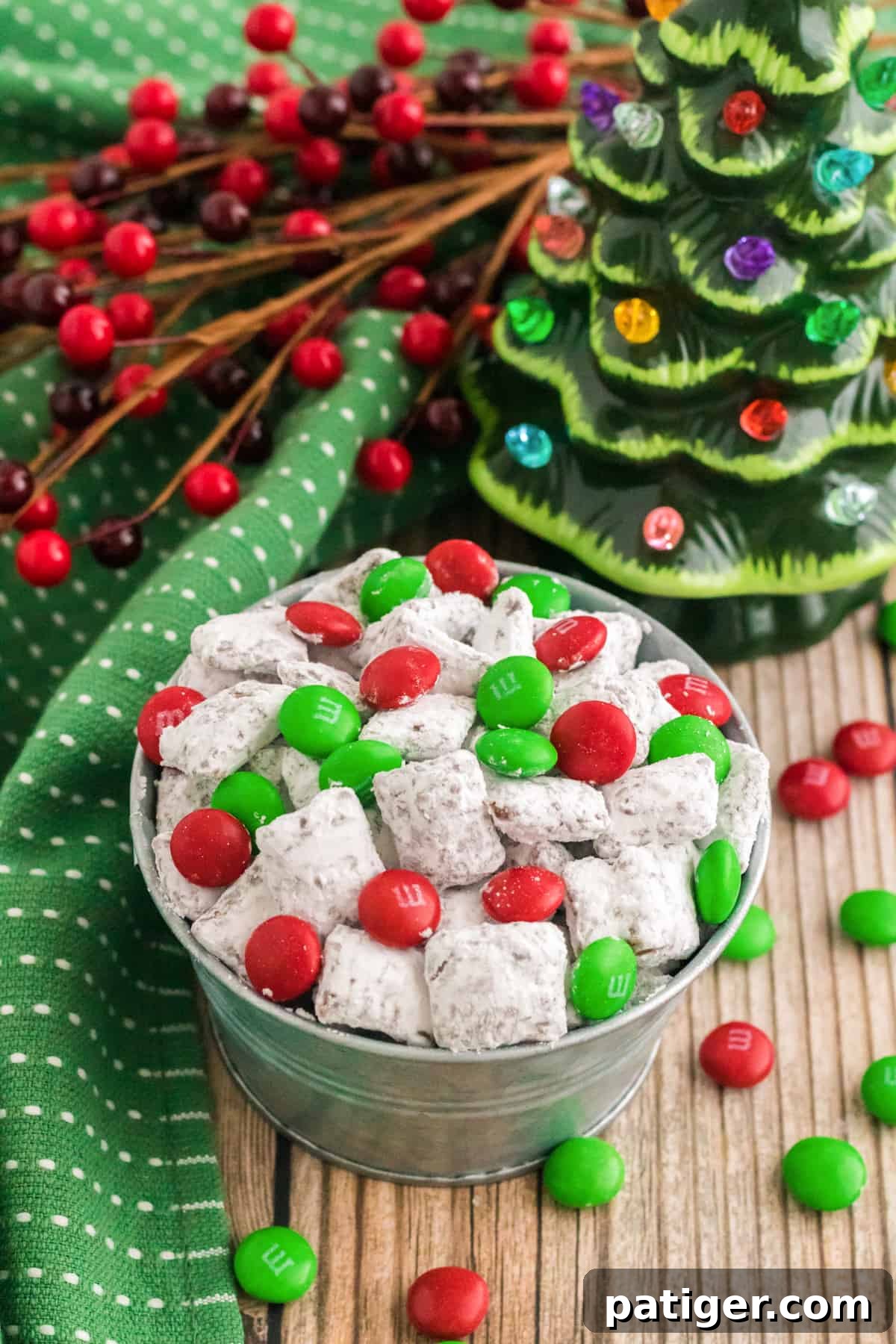 small bowl of reindeer chow with holiday M&Ms on a table with christmas decorations
