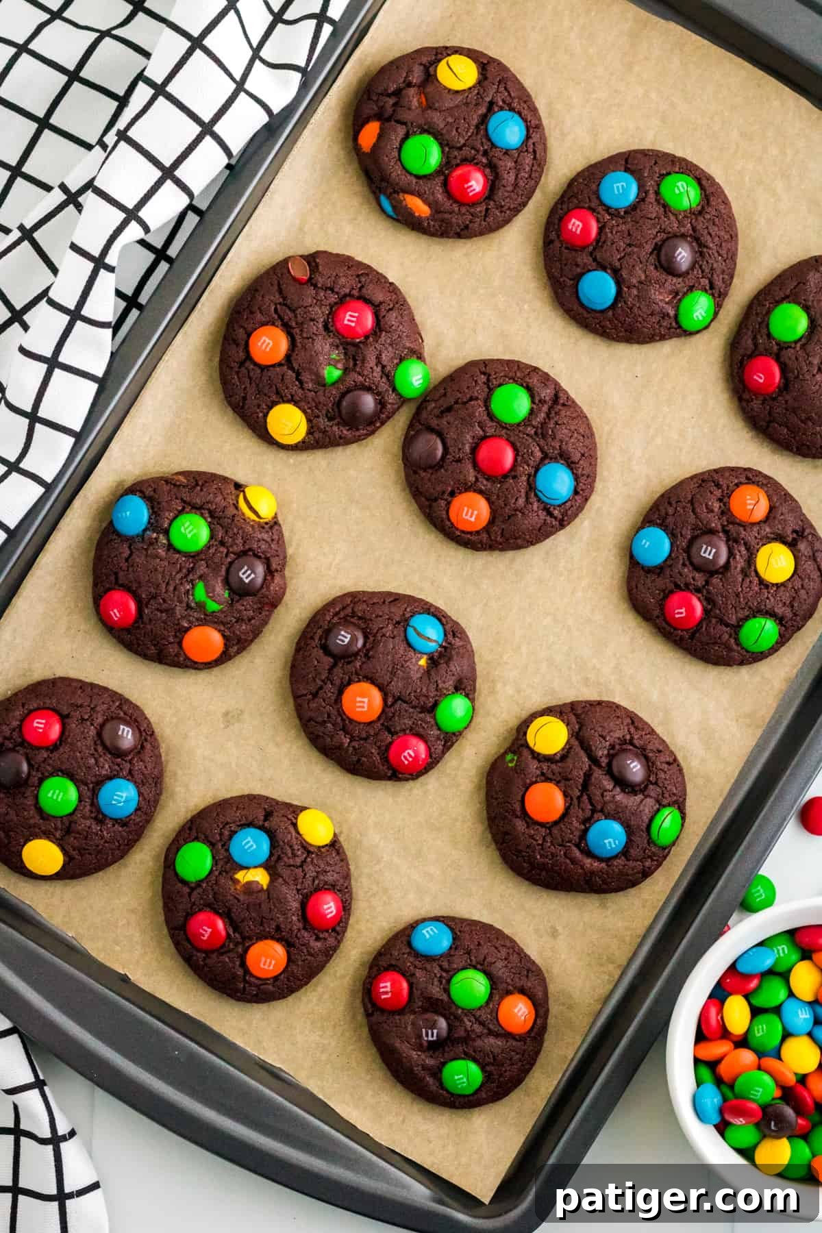 Chocolate M&M Cookies on lined baking sheet.