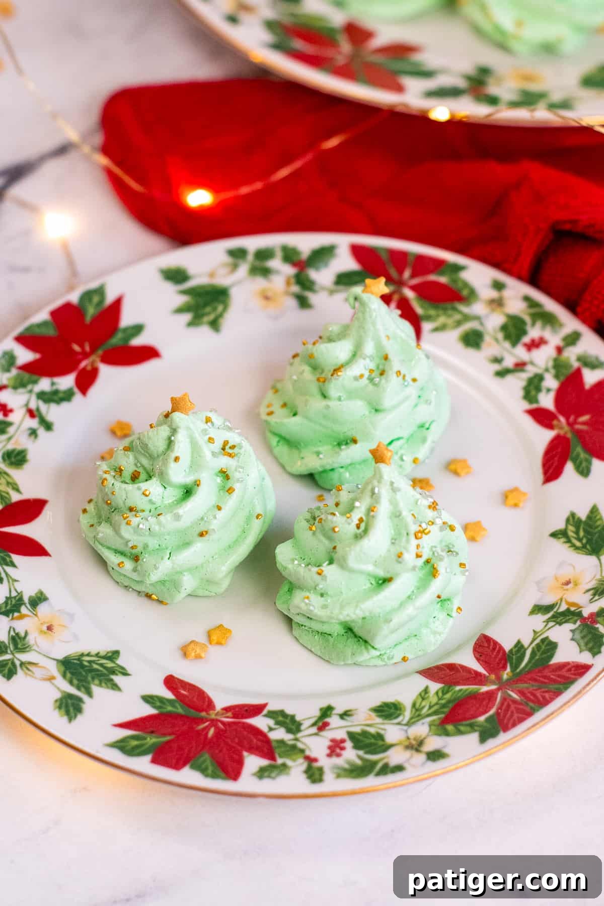 Meringue Christmas Tree Cookies on poinsettia plates.