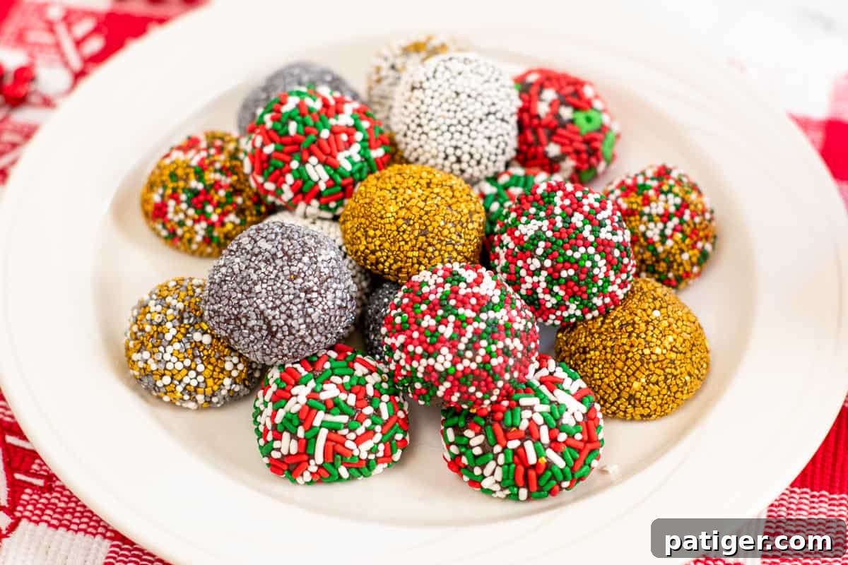 no-bake brownie batter truffles decorated with holiday sprinkles on white plate