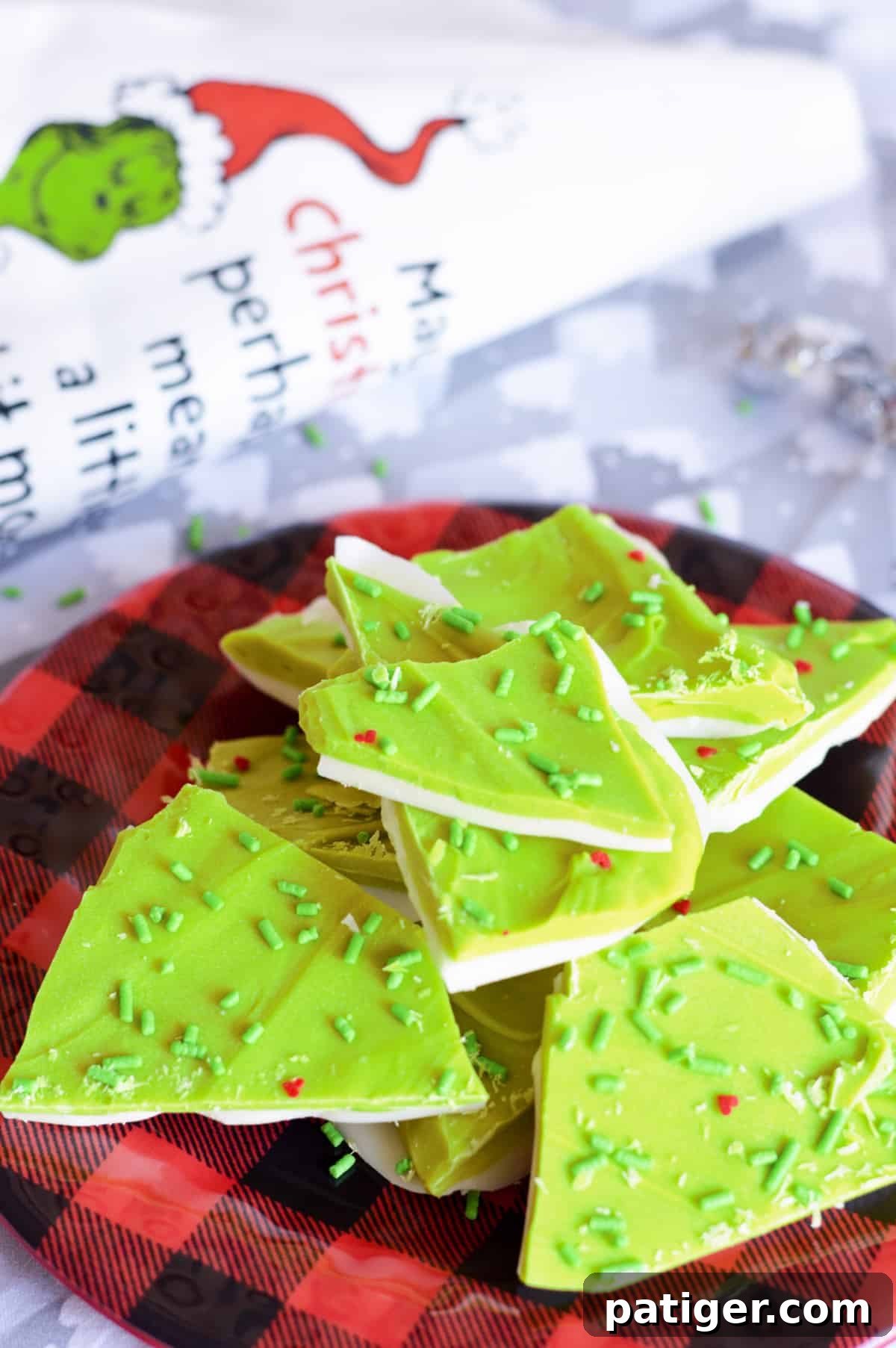 Festive Grinch Bark candy with vibrant green and white layers, topped with cheerful red hearts and sparkling green jimmies, ready for Christmas celebrations.