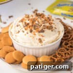 Butterfinger Candy Bar dessert dip with vanilla wafers and pretzels for dipping.