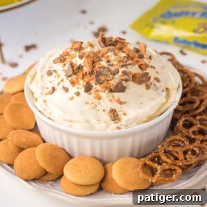 Butterfinger Candy Bar dessert dip with vanilla wafers and pretzels for dipping.