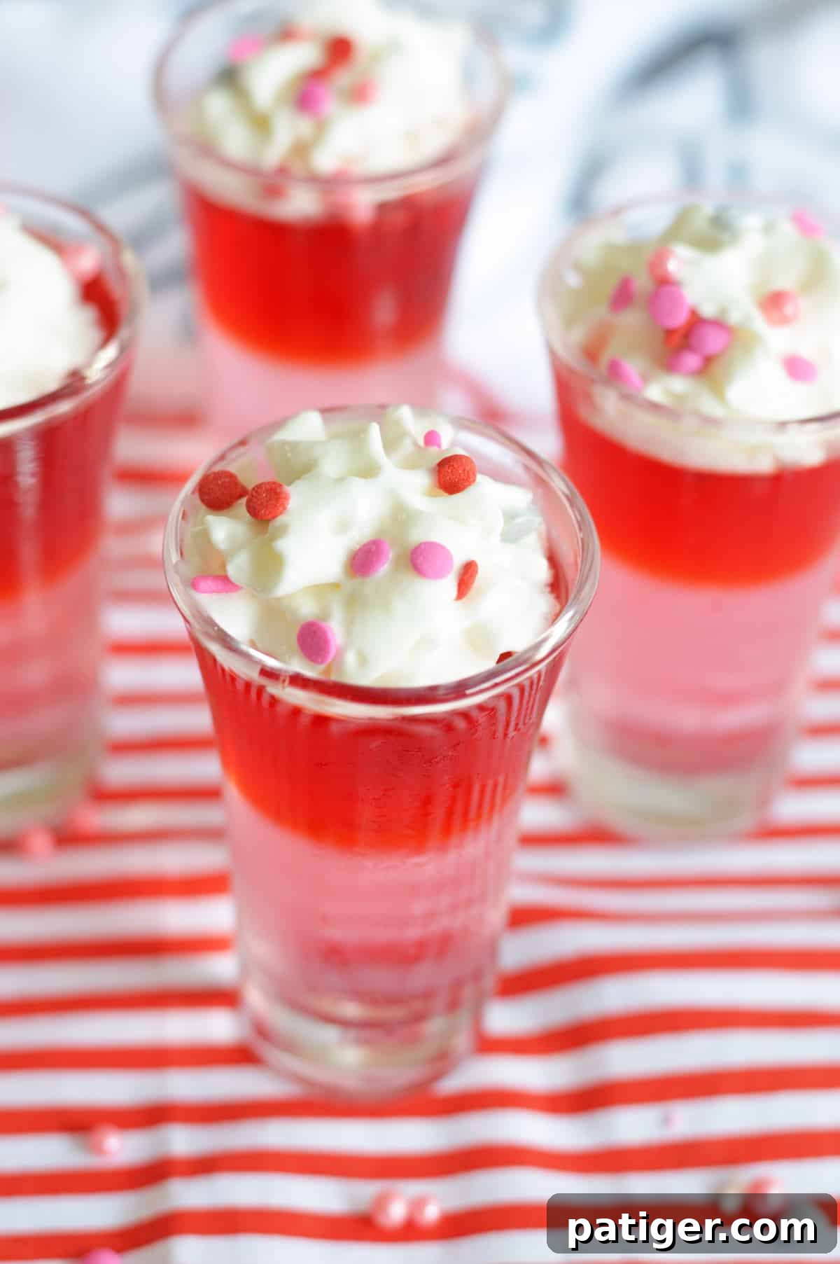 Romantic Jiggle Shots 3 Red and pink layered Jello Shots toped with whipped cream and pink and red confetti sprinkles