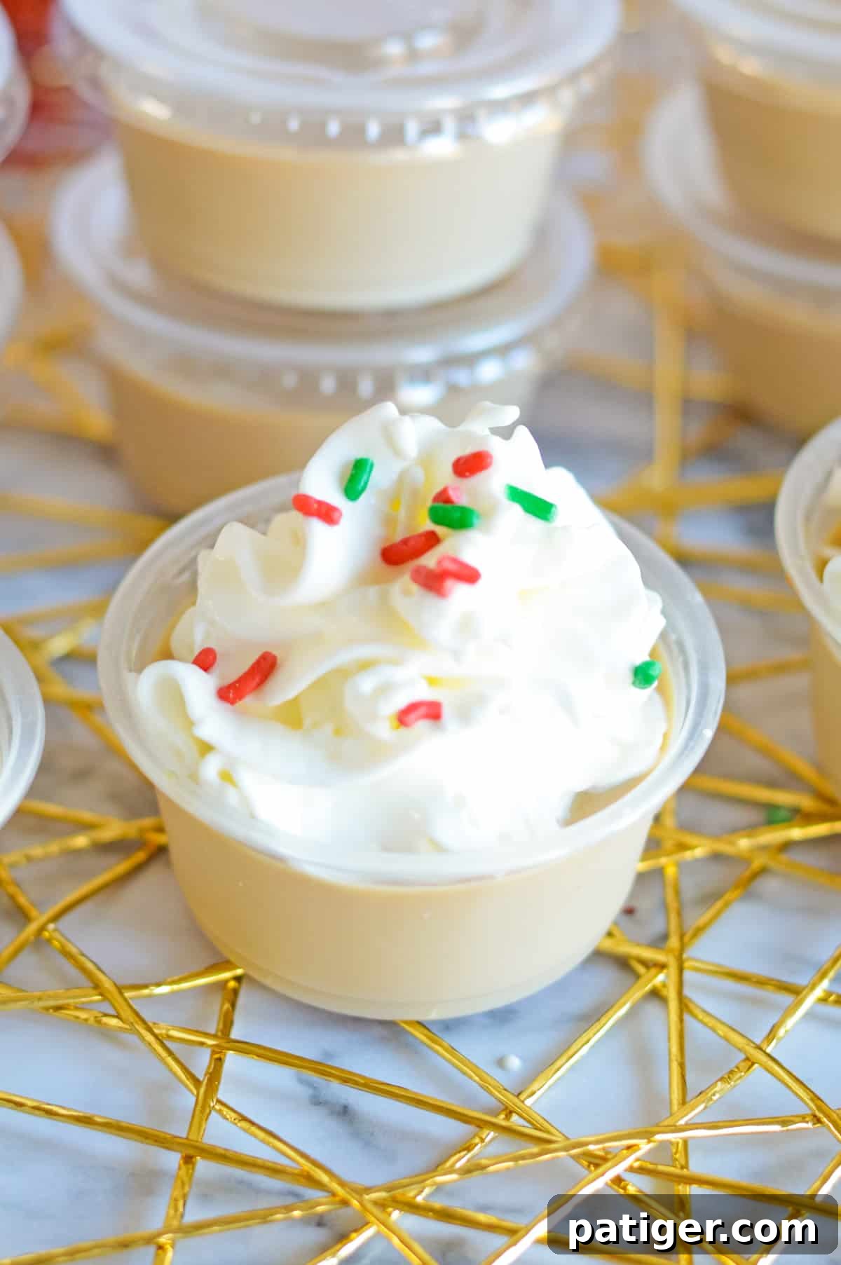 Christmas sugar cookie jello shot topped with whipped cream and red and green jimmies