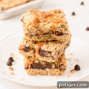 Carmelitas Cookies with sticky caramel oozing out sliced into squares and stacked on top of each other on a white plate