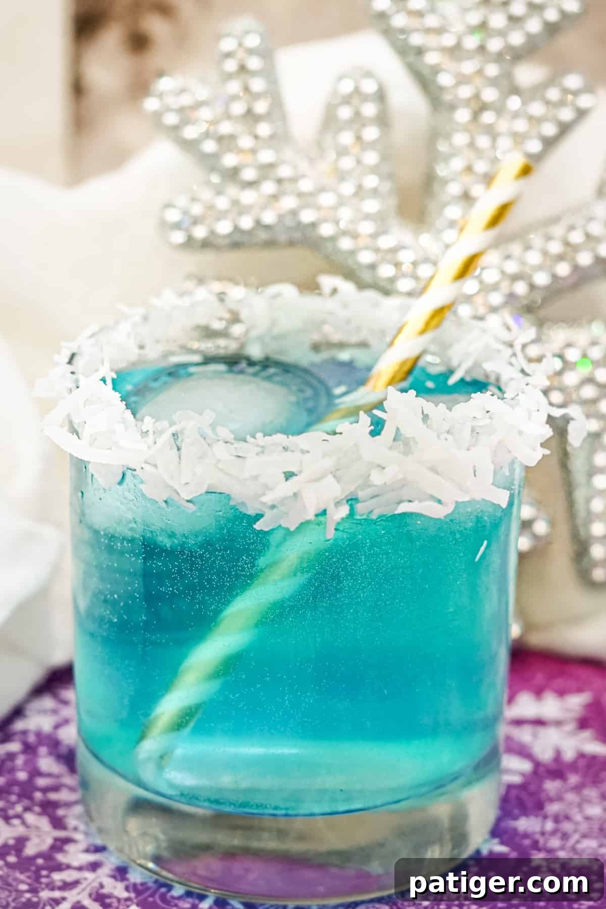 Close-up of a Jack Frost cocktail on the rocks with a coconut rim, showcasing its frosty appearance.
