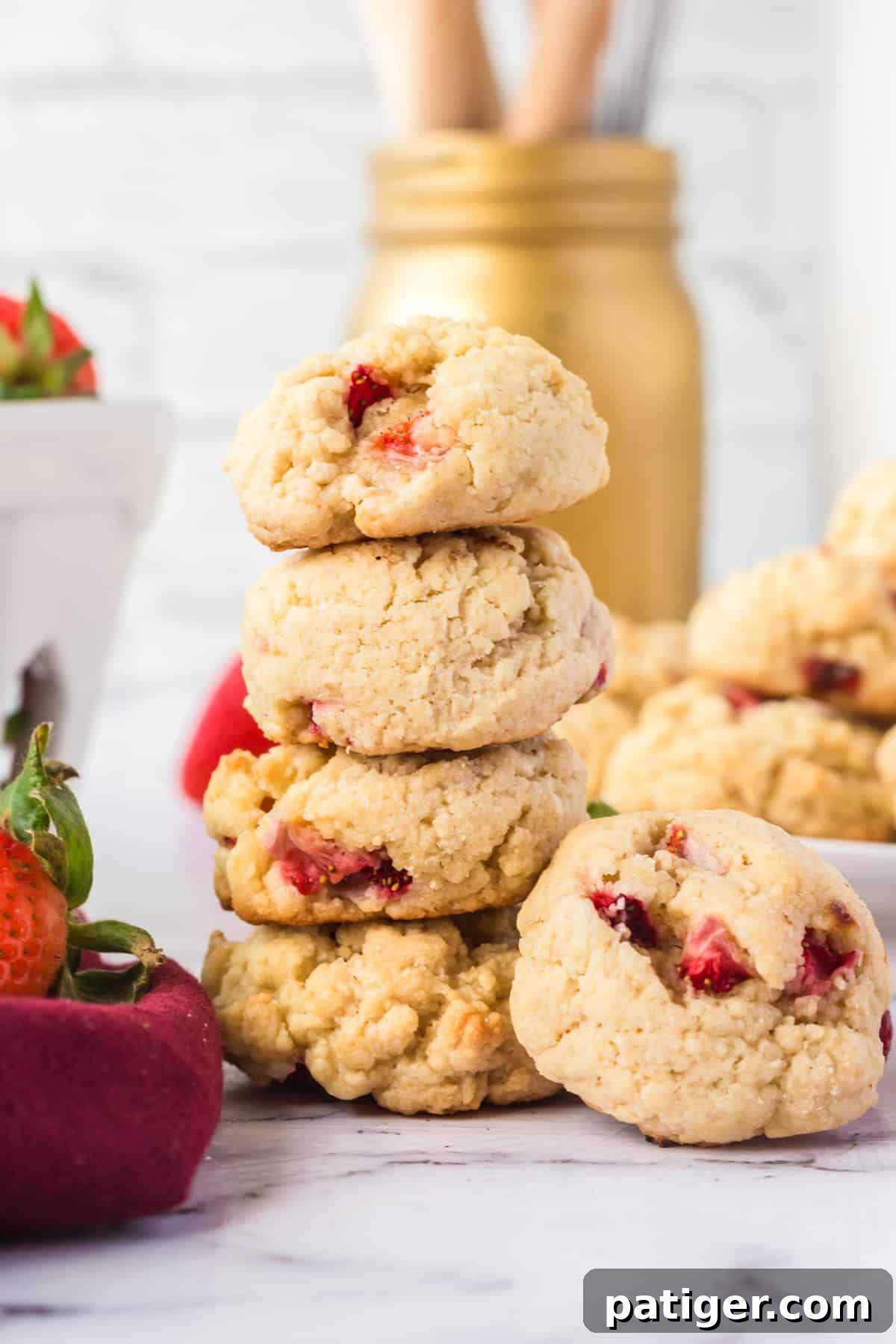 Strawberry Shortcake Cookie Bliss 3 4 fluffy strawberry cookies stacked on top of one another with additional cookies and fresh strawberries surrounding them