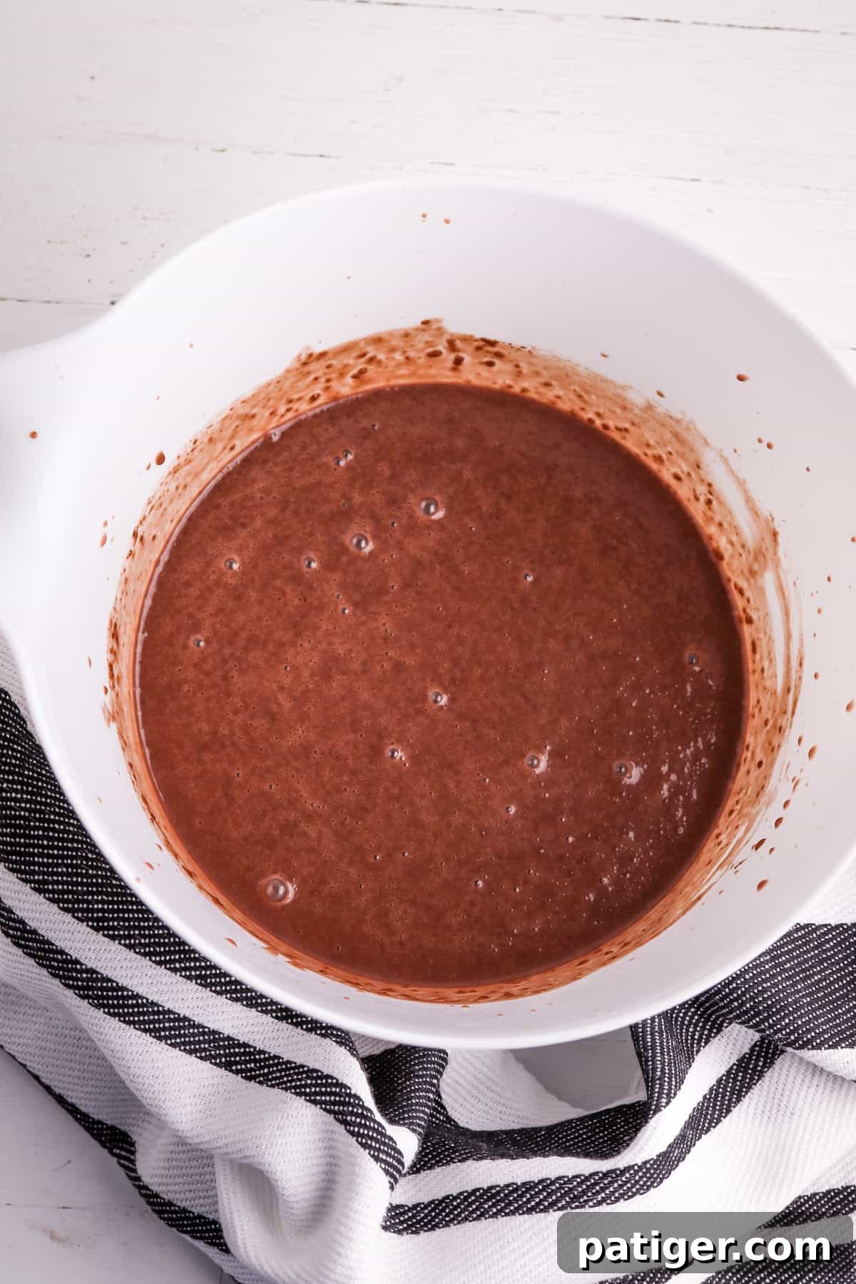 Instant chocolate pudding and cold milk whisked together in a mixing bowl, beginning to thicken for the dip recipe.