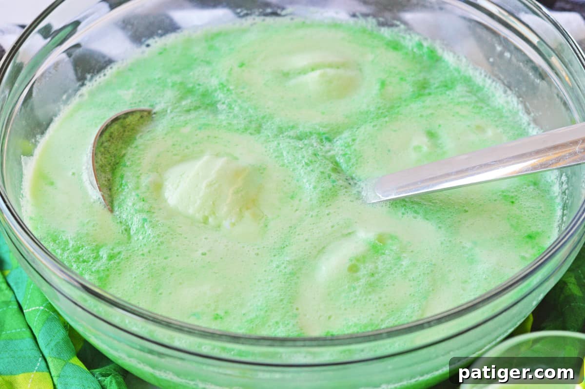 Clover Kick 3 Green Shamrock Punch in punch bowl with scoops of lime sherbet floating throughout.