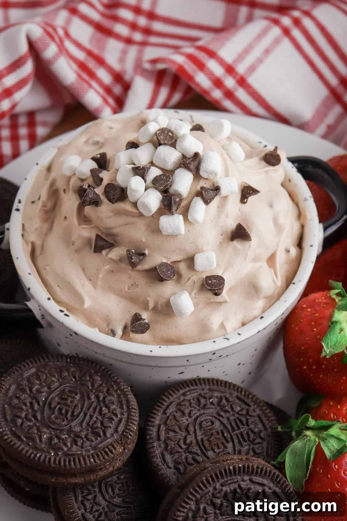 Hot Chocolate Dip topped with mini chocolate chips and marshmallow bits, served alongside OREO cookies and fresh strawberries.