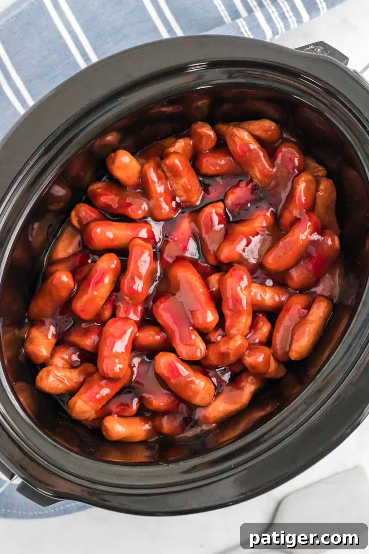 Sweet Glazed Slow Cooker Smokies 5 Lil smokies cocktail weiners in crocpot covered in bbq sauce and grape jelly.