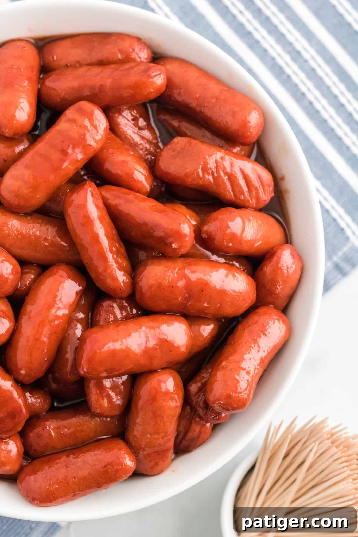Sweet Glazed Slow Cooker Smokies 8 Crockpot BBQ Little Smokies in a white serving bowl with toothpicks.