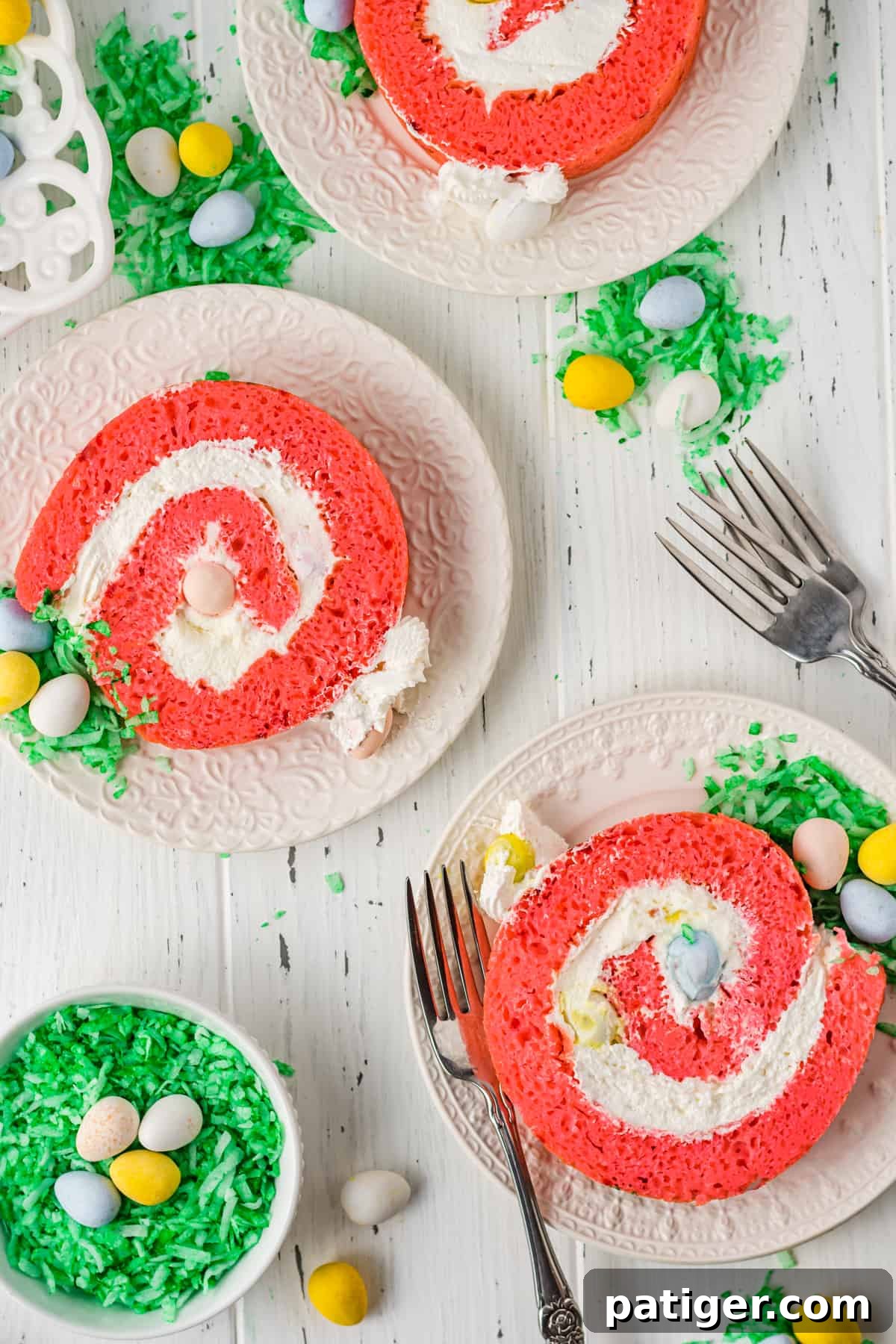 Beautifully plated slices of Easter egg roll cake, showcasing the pink cake, white cream, and colorful mini chocolate eggs, ready to be served.