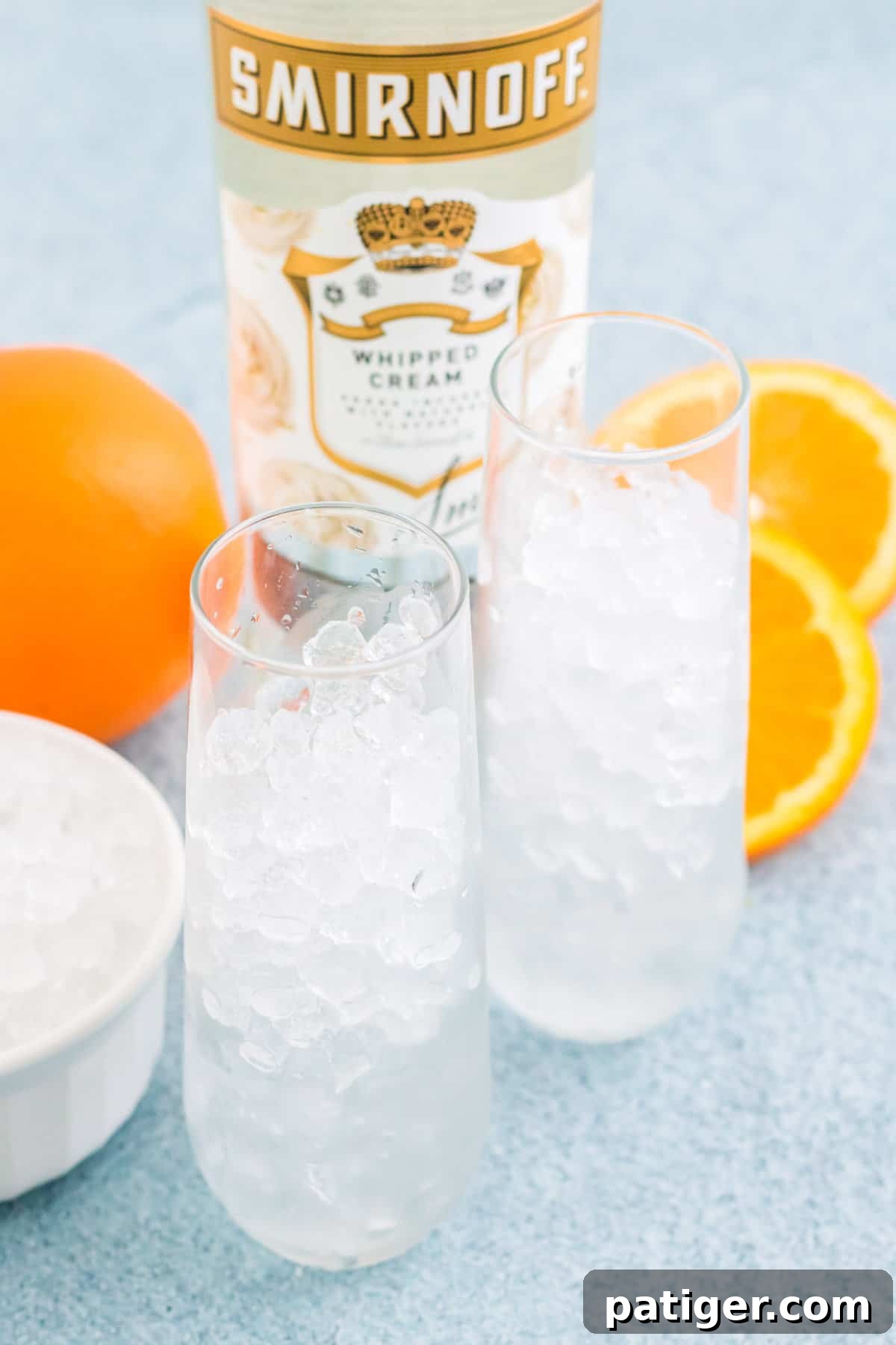 Two tall cocktail glasses brimming with crushed ice cubes, glistening and ready for the cocktail ingredients. The ice is perfectly mounded, promising a thoroughly chilled drink.