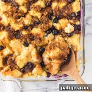 Blueberry French Toast Casserole with spoon scooping out a serving.