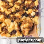 Blueberry French Toast Casserole with spoon scooping out a serving.