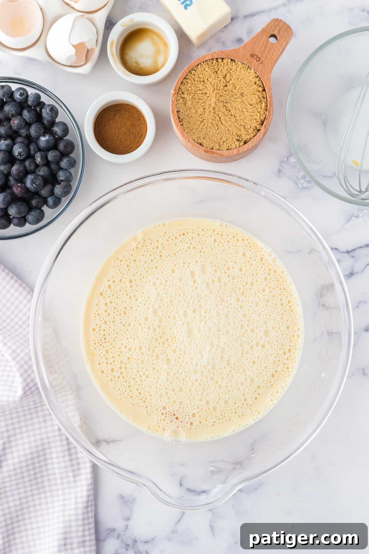 Close-up of the egg custard mixture being whisked in a bowl for the French toast casserole.