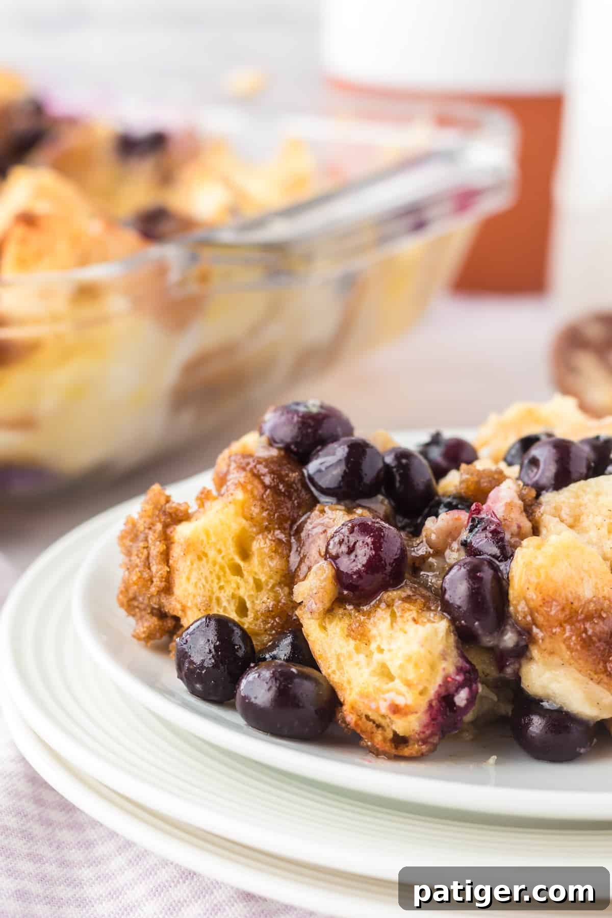 A delightful serving of blueberry French toast breakfast casserole on a white plate, ready to be enjoyed.