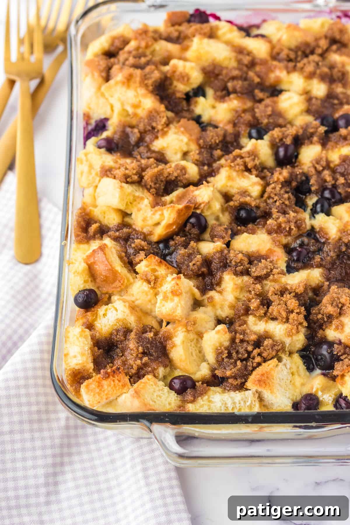 A vibrant blueberry overnight French toast casserole cooling in a 9x13 inch baking dish.