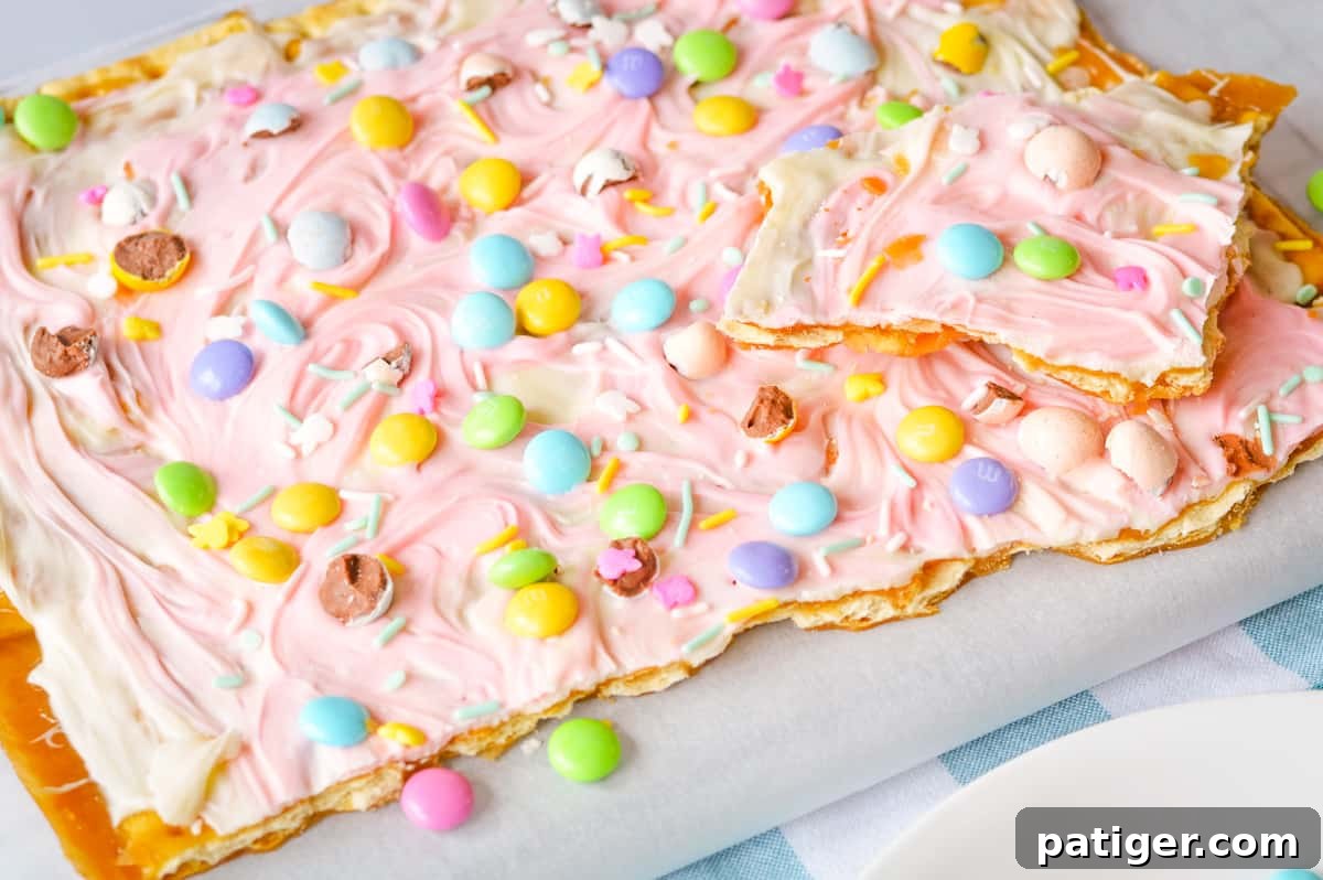 Pastel saltine toffee being broken into pieces.