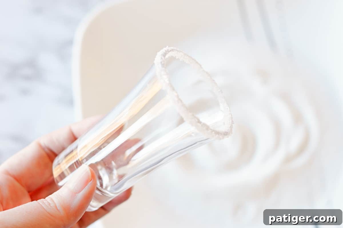 Shot glass being dipped in to a plate of sugar.