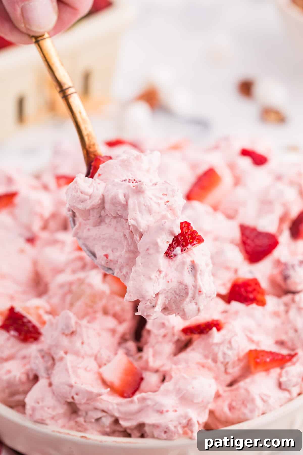 Strawberry Cloud Salad 8 Spoonful of strawberry fluff being lifted out of the servings bowl.