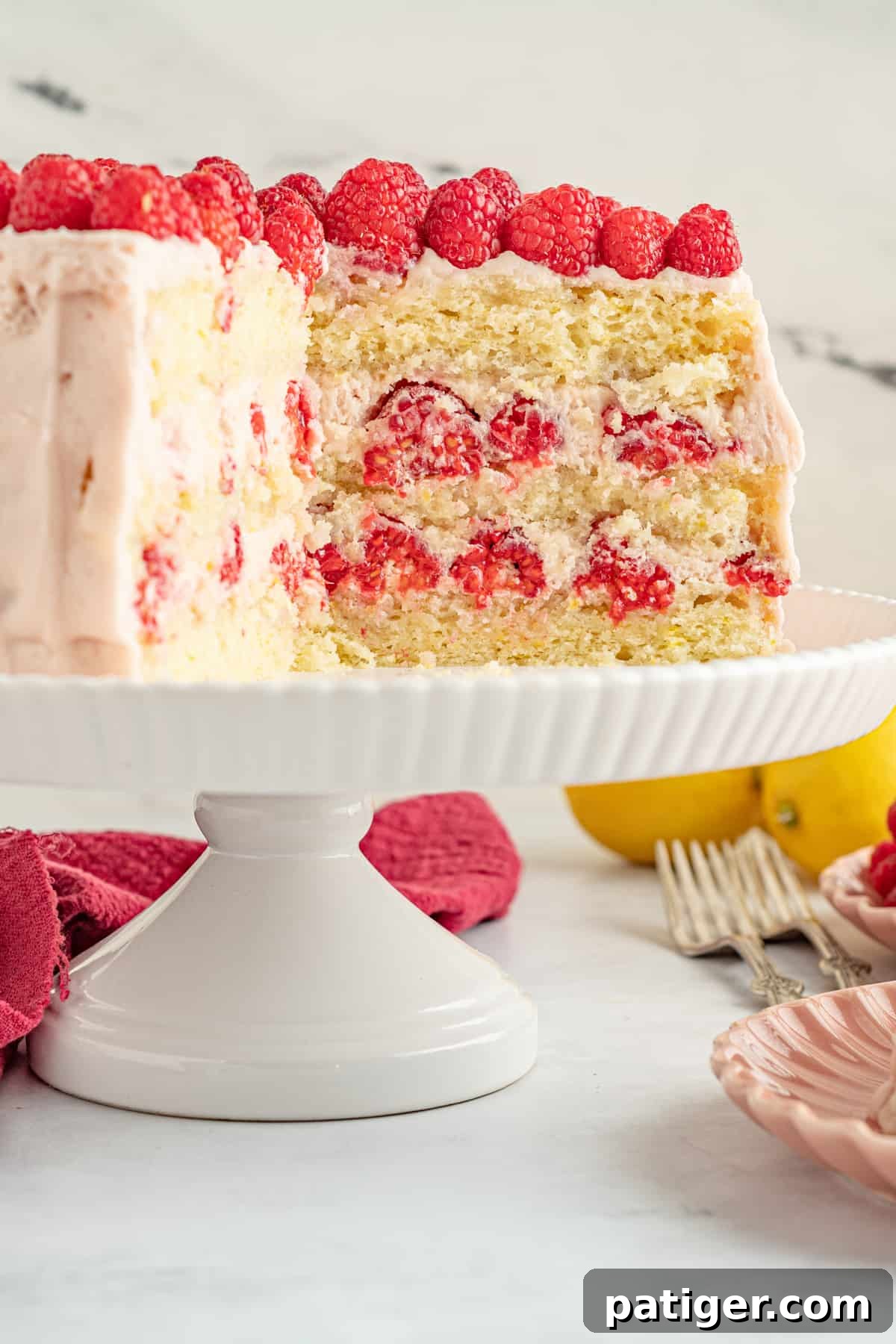 Lemon raspberry cake with three distinct layers of yellow cake, raspberry filling, and frosting.