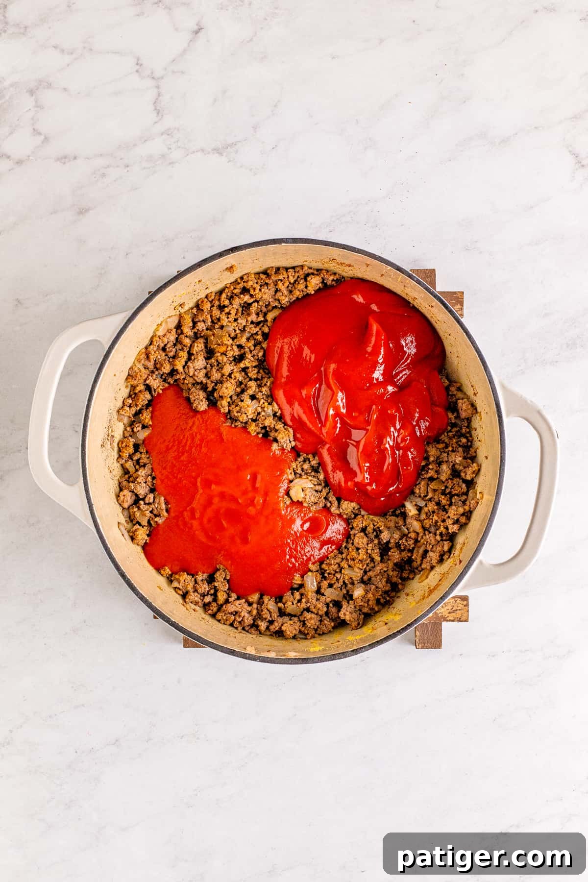 Pot of hot dog chili with liquid ingredients added.