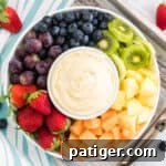 Cream cheese fruit dip on a platter surrounded by fresh fruit.