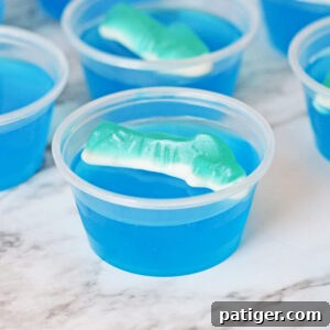 Shark jello shot with blue gelatin and shark gummy candy on top.