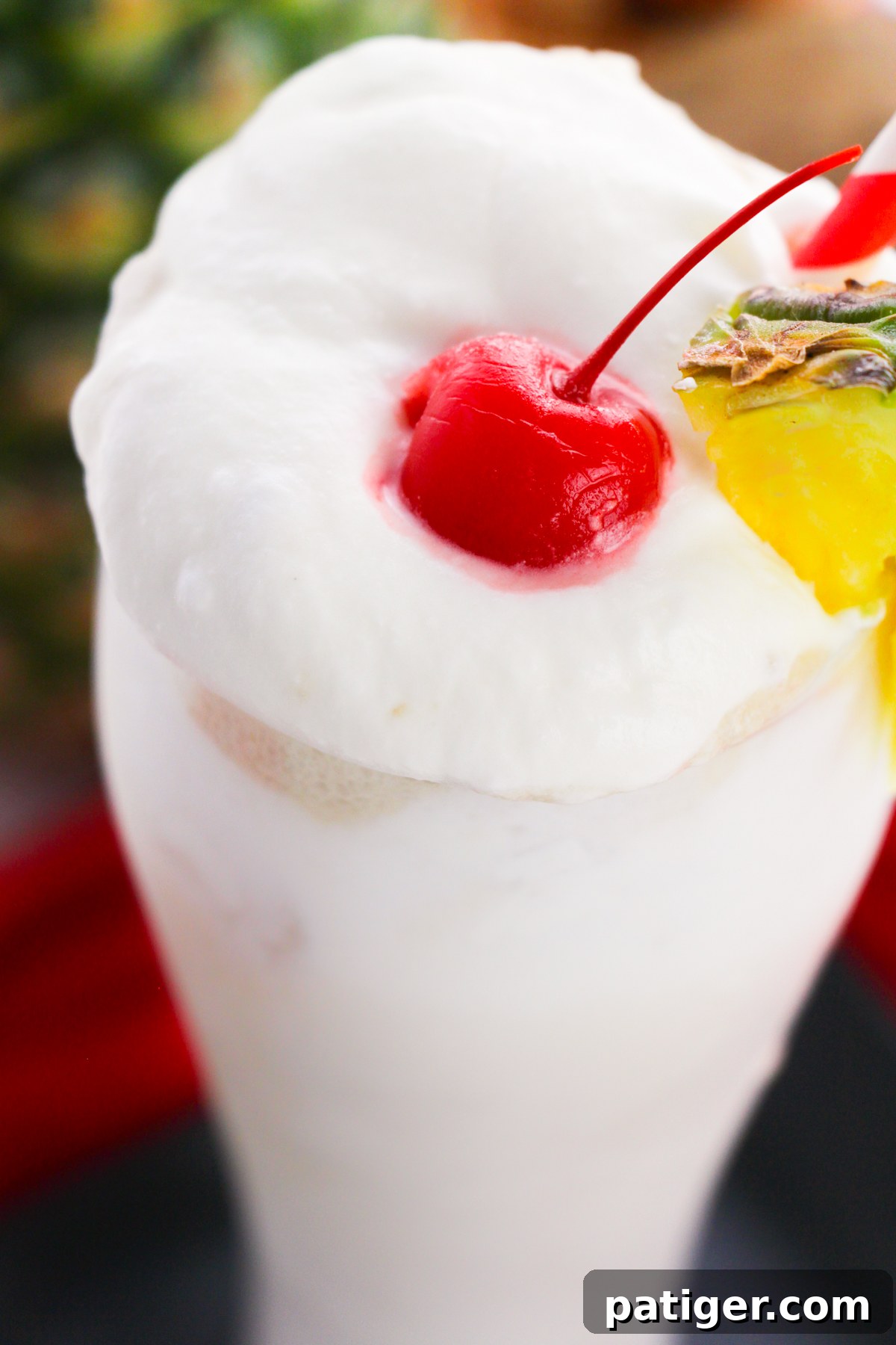 Frosty Island Escape 6 Creamy white frozen cocktail topped with whipped cream, cherry, and pineapple.