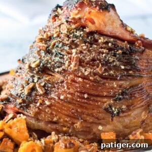 Pecan Glazed Ham with sweet potatoes in serving dish.