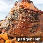 Pecan Glazed Ham with sweet potatoes in serving dish.