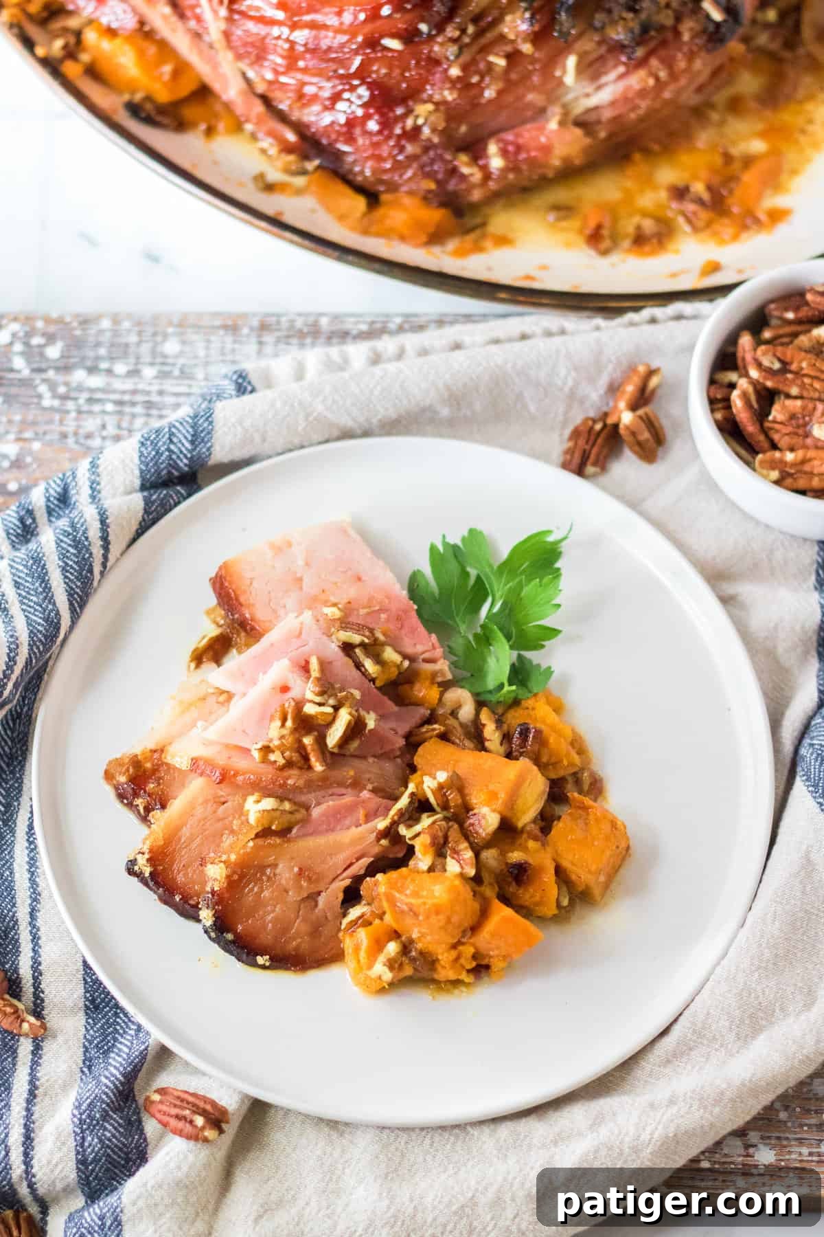 Sliced maple pecan ham served beautifully with roasted sweet potatoes.