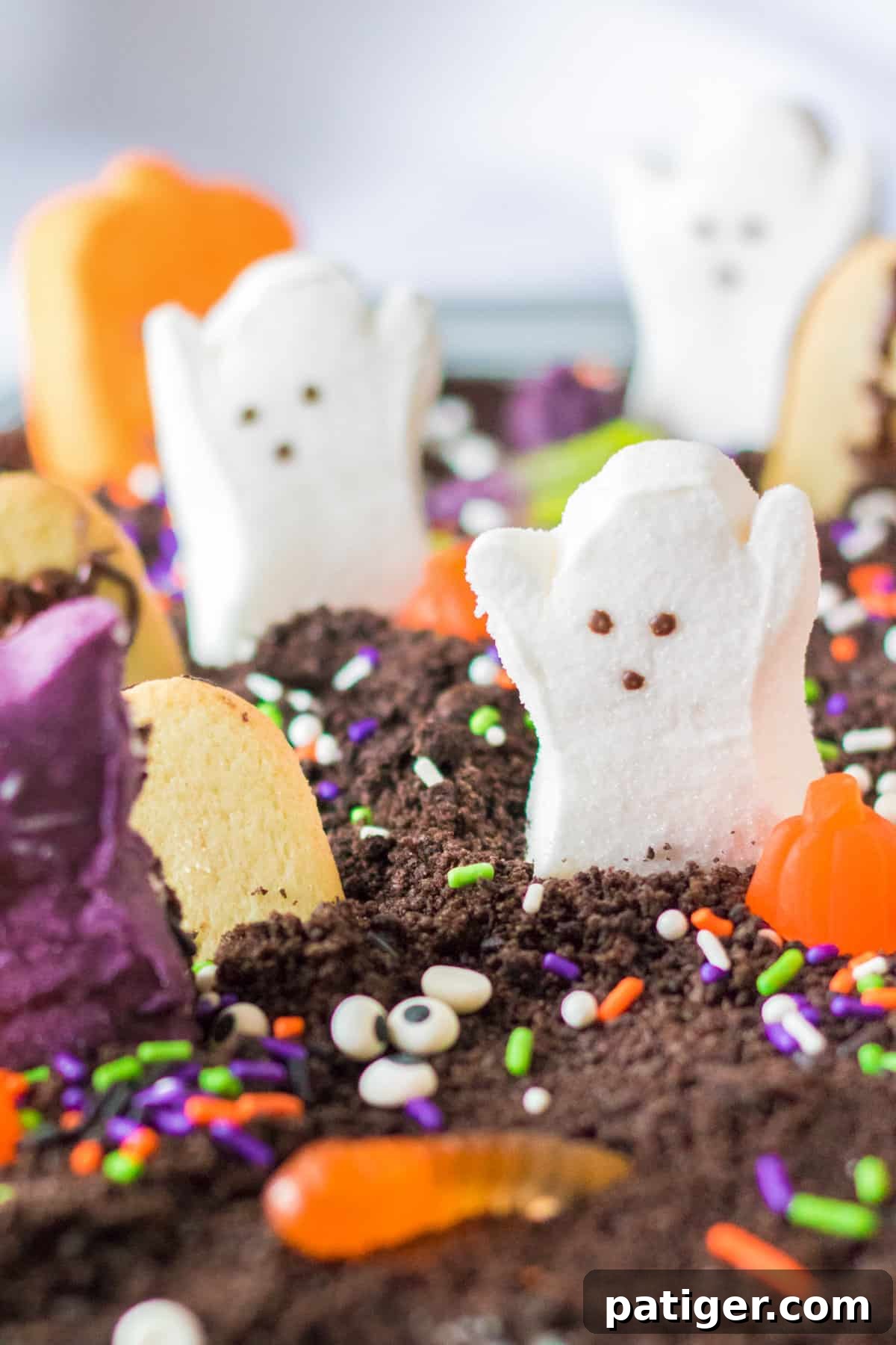 Haunted Cemetery Poke Cake 11 Cake covered with oreo cookie crumbs and topped with Halloween Peeps and other candies.