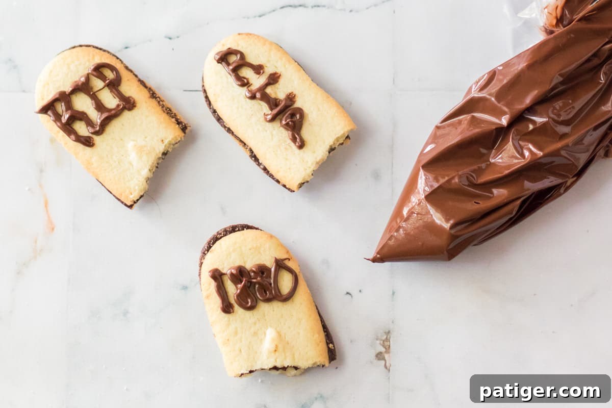Haunted Cemetery Poke Cake 8 Piping chocolate onto milano cookies to make tombstones.