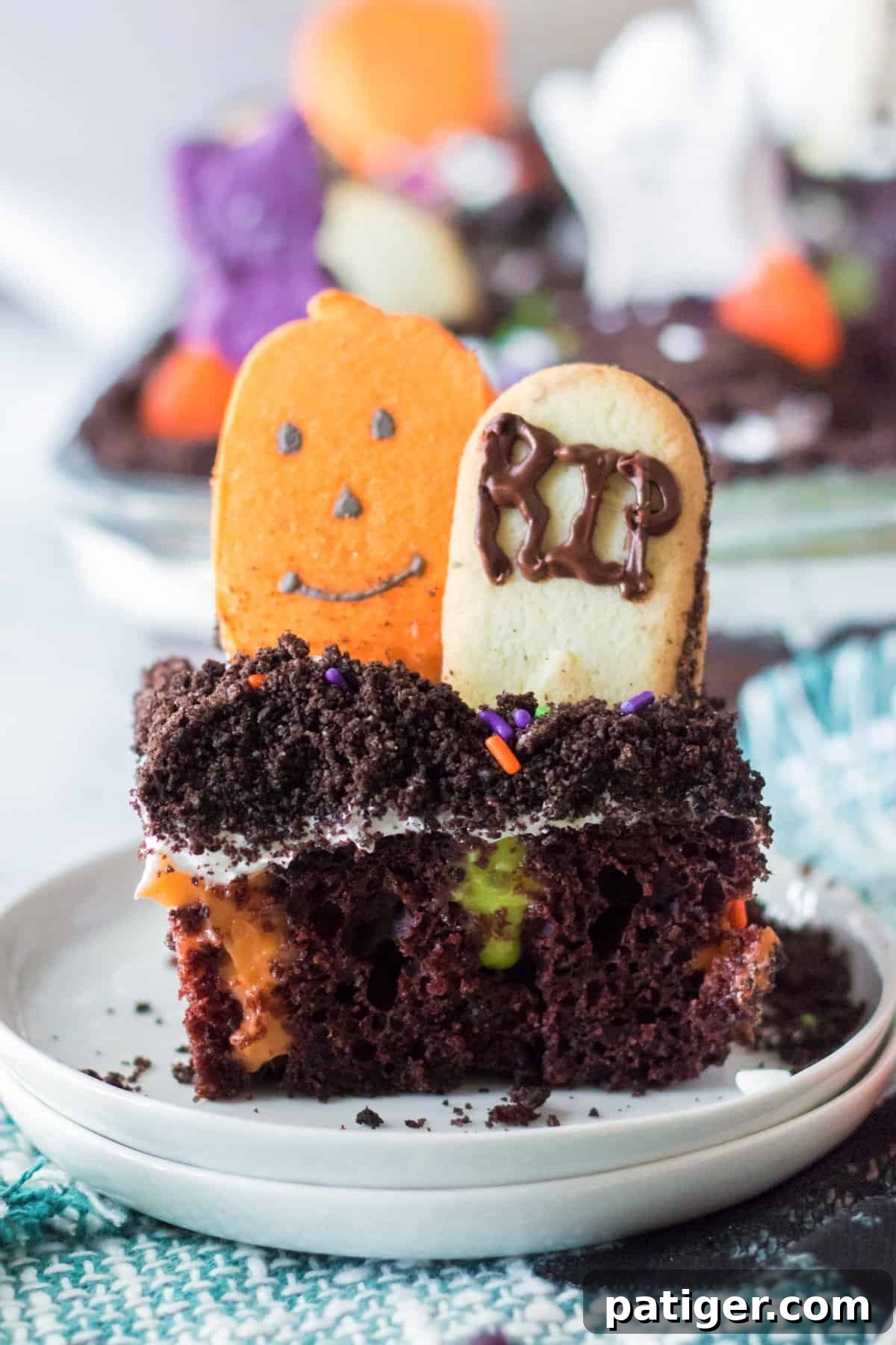 Haunted Cemetery Poke Cake 10 Piece of Ghosts in the Graveyard poke cake with cookie tombstone and candy pumpkin.