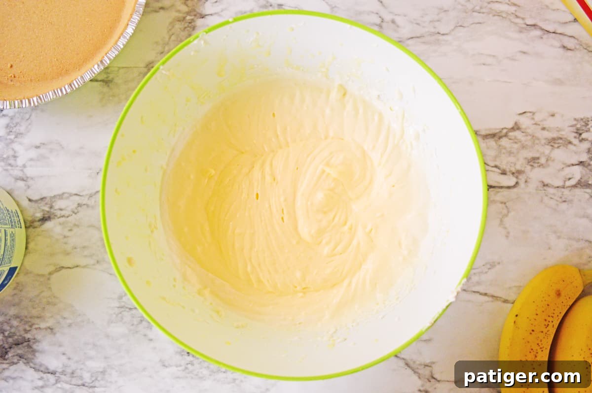 Banana pudding and cream cheese mixture, now lightened with Cool Whip, in a mixing bowl.